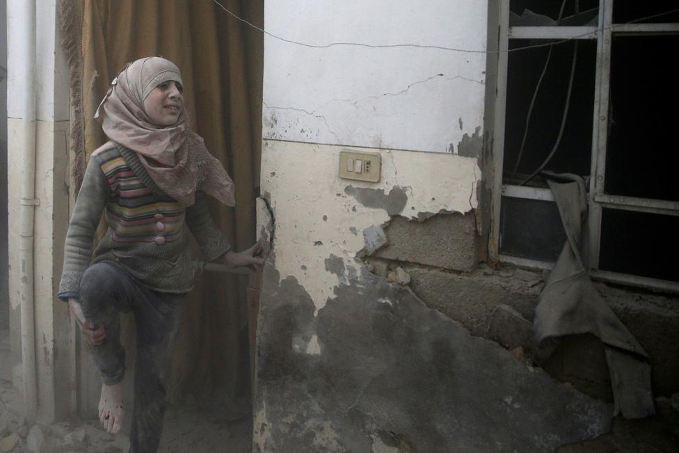 An injured girl reacts at a site hit by an airstrike in the rebel-held Douma neighbourhood of Damascus