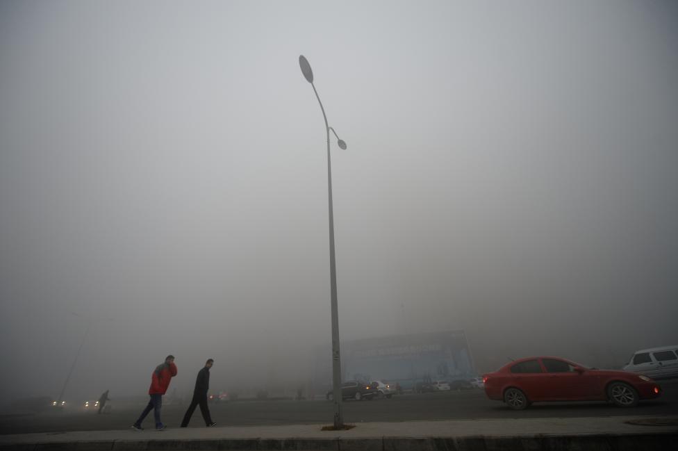 People walk in heavy smog during a polluted day in Jinan, Shandong province. REUTERS/Stringer